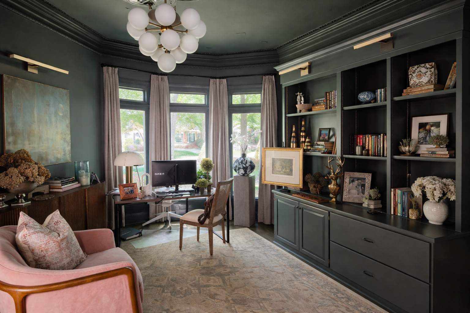 The finished midcentury study in deep slate green with the client's art, custom maple bookcase and bay window